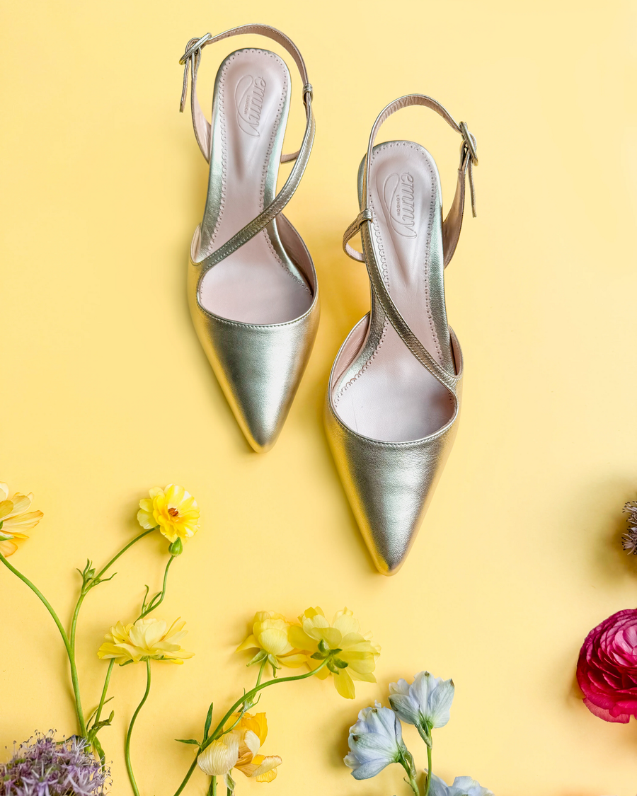 Gold low-heeled shoes on a yellow background with flowers image