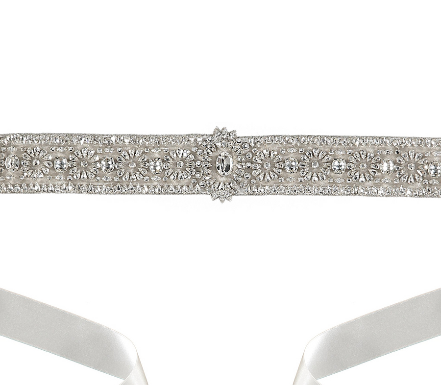This image features a close-up of a decorative shoe strap adorned with intricate rhinestone embellishments. The strap is set against a plain white background, highlighting its sparkling details. The angle of the image focuses on the embellishments, showcasing the craftsmanship and design of the strap. image