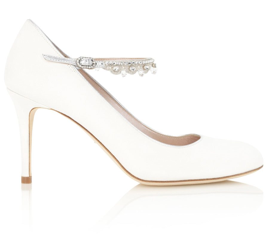 White high-heeled shoe with a rounded toe and a delicate ankle strap adorned with small decorative beads. The shoe features a sleek silhouette and is set against a clean, reflective background, showcasing its elegant design. The heel height is approximately 4 inches. image