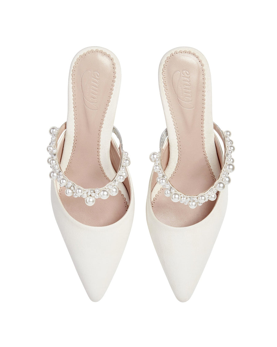 White pointed-toe heels with a decorative pearl strap across the front. The shoes are displayed from a top-down angle against a plain white background, showcasing their sleek design and elegant detailing. image