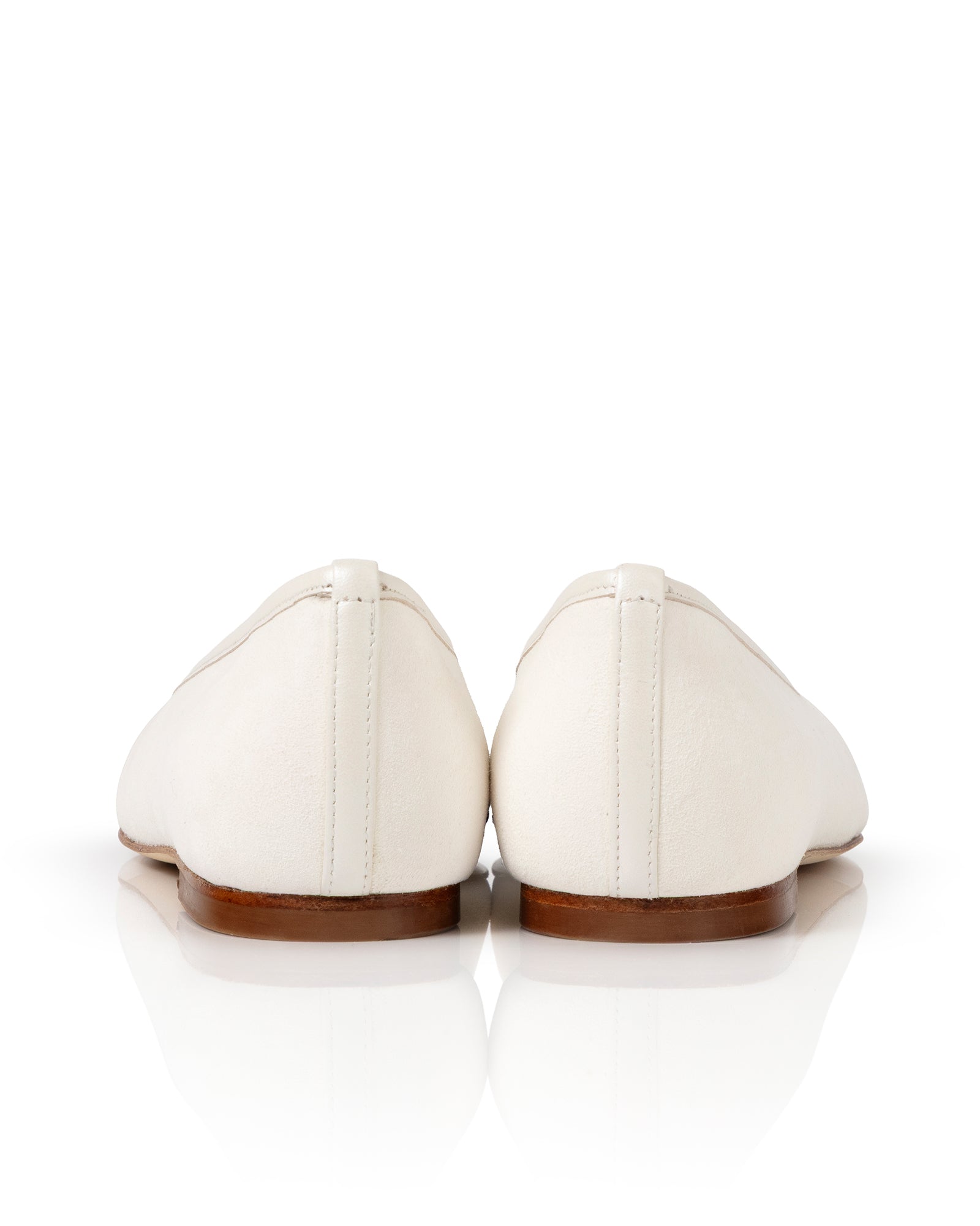 Pair of white shoes with brown soles on a white background image