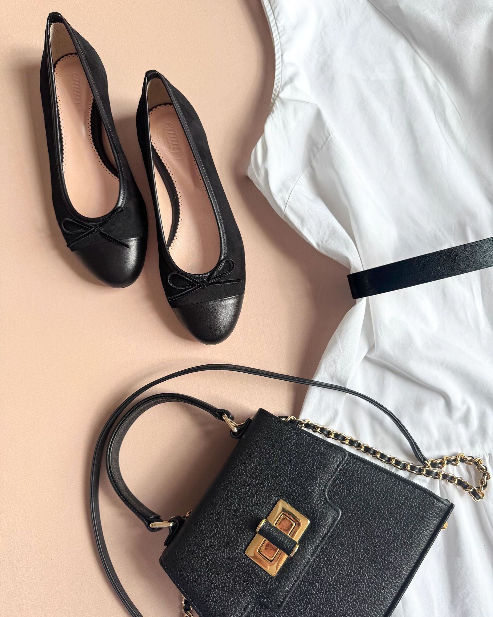 Black shoes and black handbag on a beige and white background image