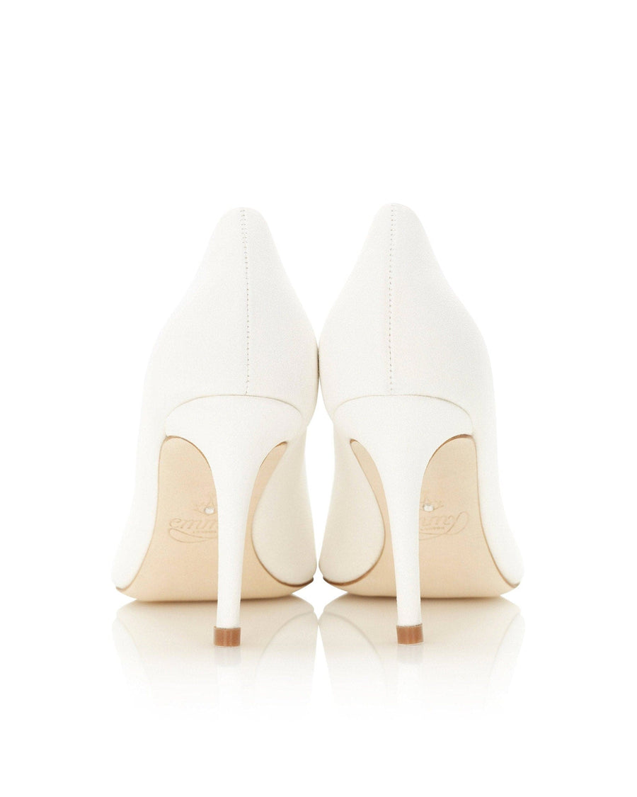 White leather heels with a pointed toe and a sleek design. The image shows the back view of the shoes, highlighting the elegant stiletto heel. The background is a clean, white surface, emphasizing the shoes' minimalist style. image