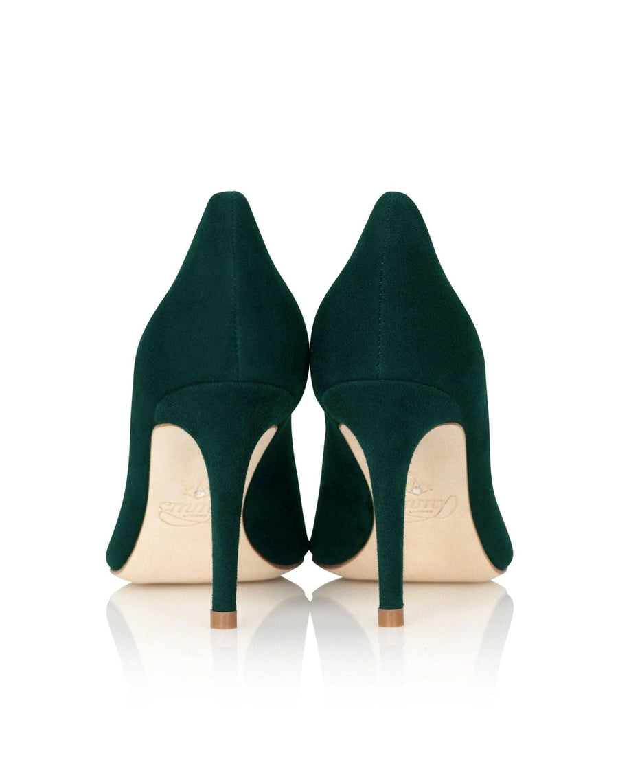 Green suede heels with a sleek design, featuring a pointed toe and a stiletto heel. The image is taken from the back, showcasing the elegant silhouette against a reflective surface. image