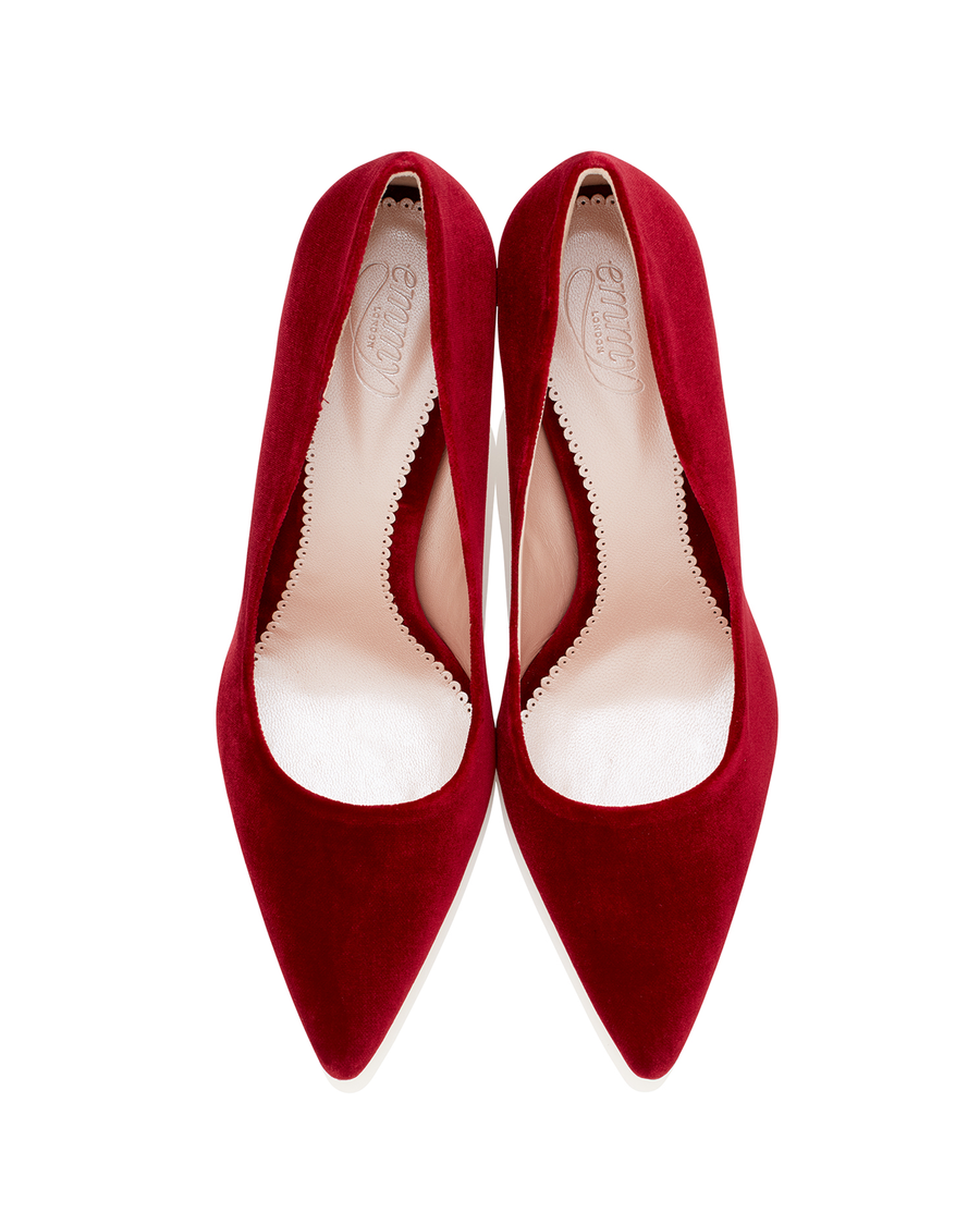 Red suede high heels with a pointed toe design, displayed from a top-down angle against a white background. The interior features a smooth lining, highlighting the elegant shape of the shoes. image