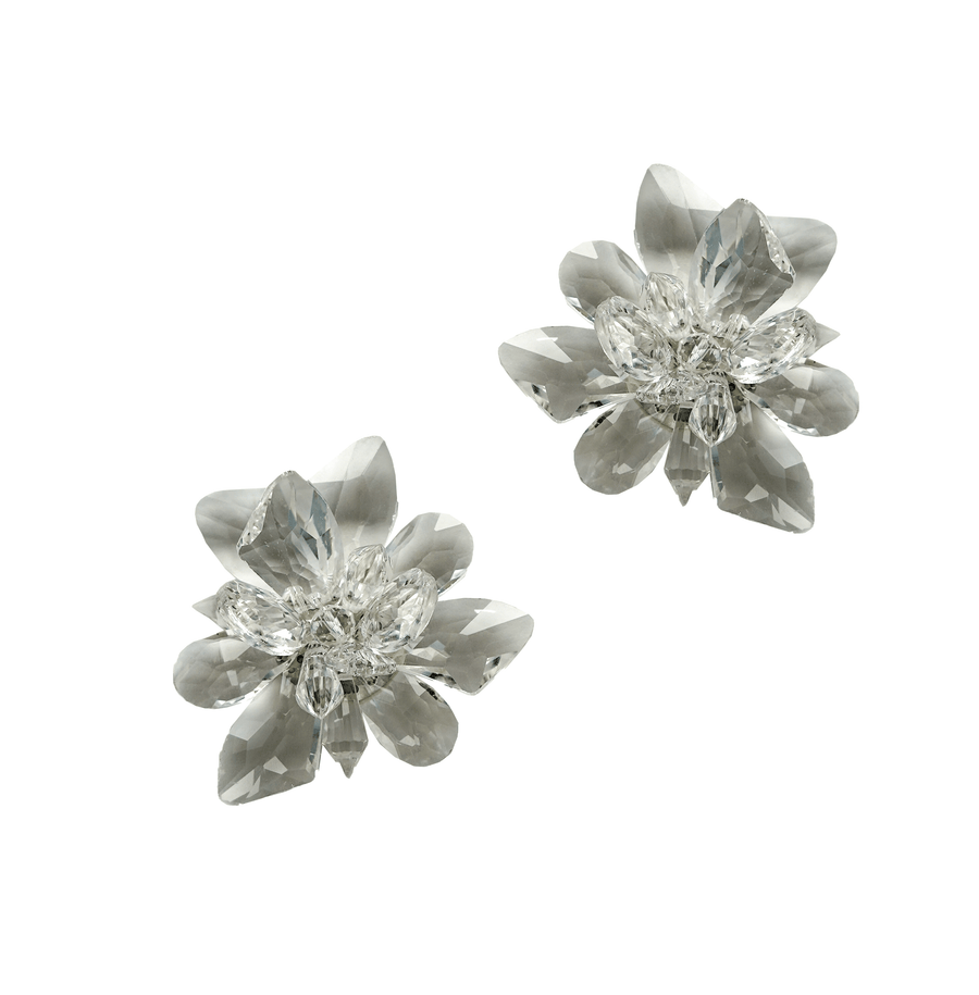 The image features a pair of elegant floral-shaped earrings made of clear crystals, showcasing intricate detailing and a sparkling finish. The earrings are displayed against a plain white background, allowing the brilliance of the crystals to stand out. image
