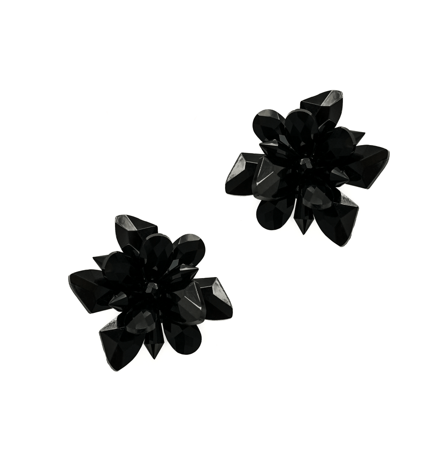 Black floral-shaped earrings made of glossy material, featuring multiple petal-like elements. The image is set against a plain white background, showcasing the earrings from a top-down angle. image