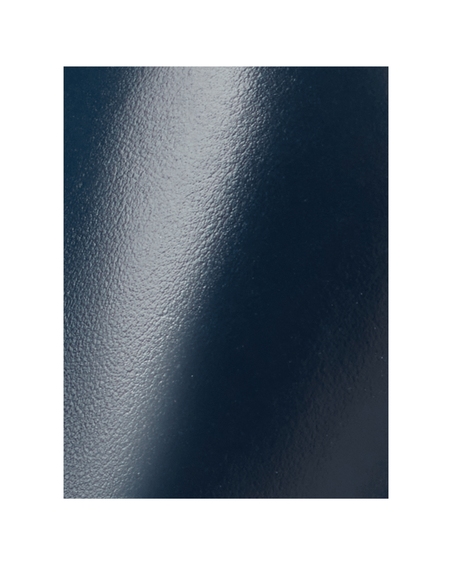 The image shows a close-up of a glossy navy surface, likely representing a shoe material. There are no visible details regarding heel height or the overall design of a shoe. image