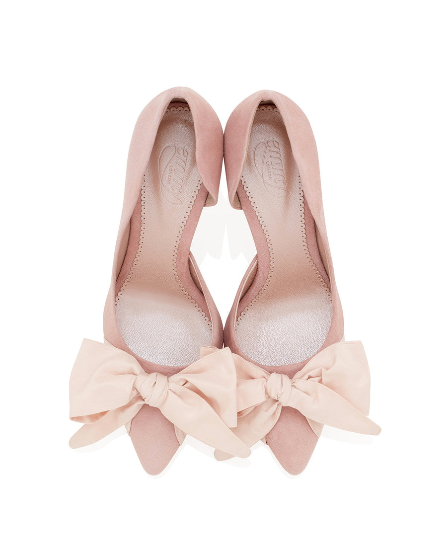 Pink suede heels with a pointed toe design, featuring large bow accents at the front. The shoes are displayed from a top-down angle against a white background, highlighting their elegant shape and soft texture. image