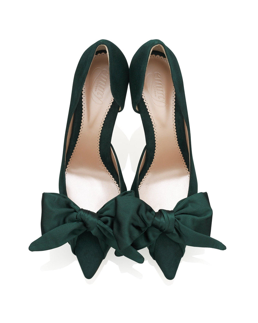 Green suede heels with a pointed toe design and a large bow detail at the front. The shoes are displayed from a top-down angle against a white background, showcasing the elegant silhouette and the soft texture of the material. image