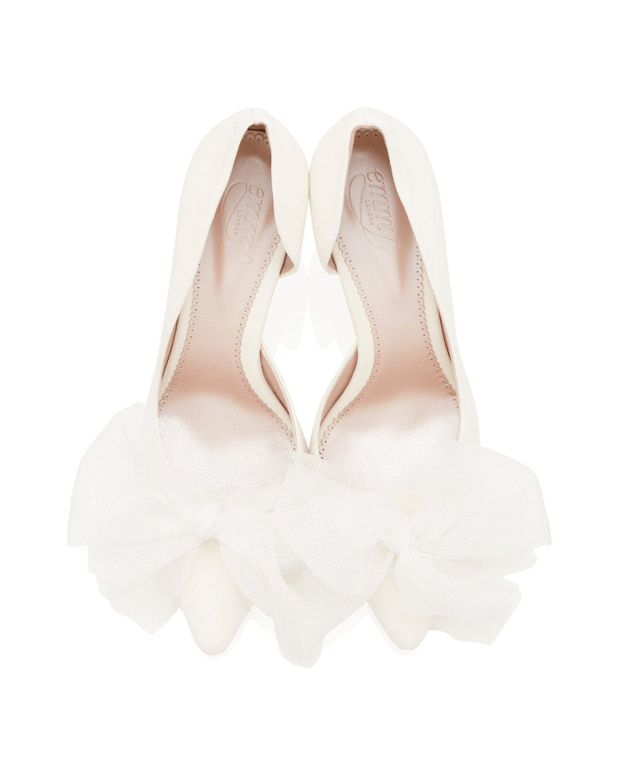 White leather heels featuring a pointed toe design, adorned with a large, delicate white tulle bow at the front. The shoes are displayed from a top-down angle against a plain white background, emphasizing their elegant silhouette. image