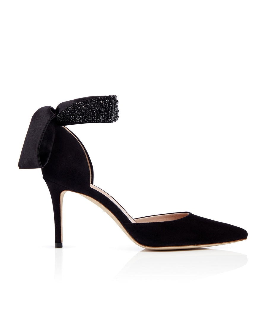 Black suede heels with a pointed toe and a decorative ankle strap featuring black beading. The shoes are displayed against a white background, showcasing their elegant design and sleek silhouette. The heel height is approximately 4 inches. image