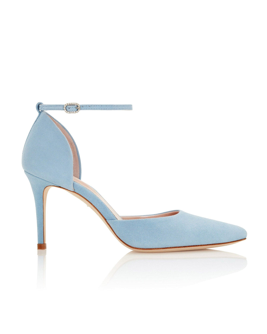 Light blue suede heels with a pointed toe and an ankle strap featuring a small embellishment. The shoes are displayed against a white background, showcasing their elegant design and sleek silhouette. The heel height is approximately 4 inches. image