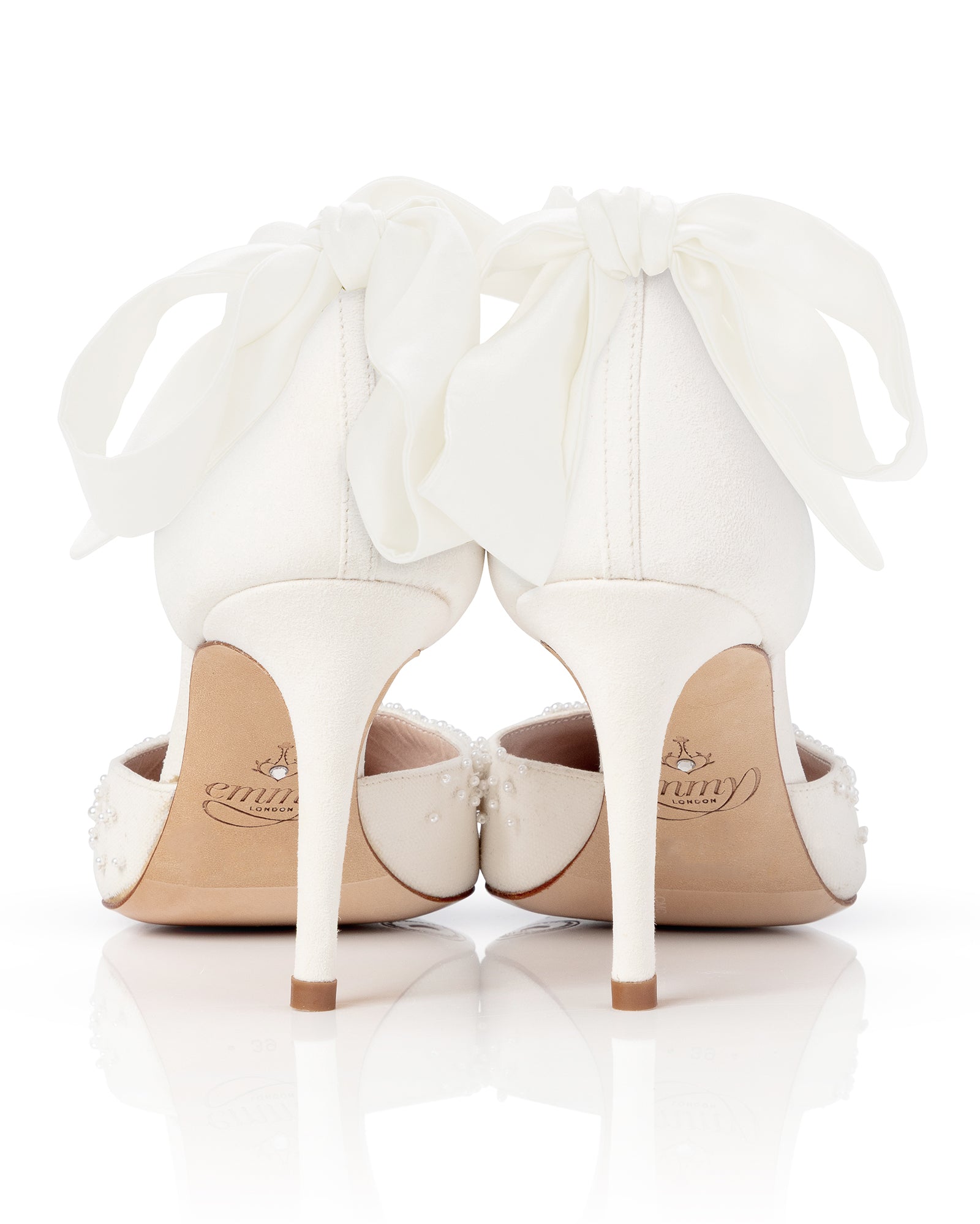 White high-heeled shoes with decorative bows on a white background image