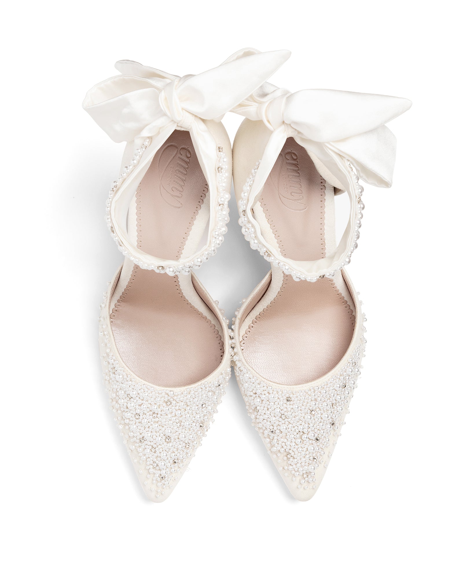 White high-heeled shoes with decorative bows on a white background image