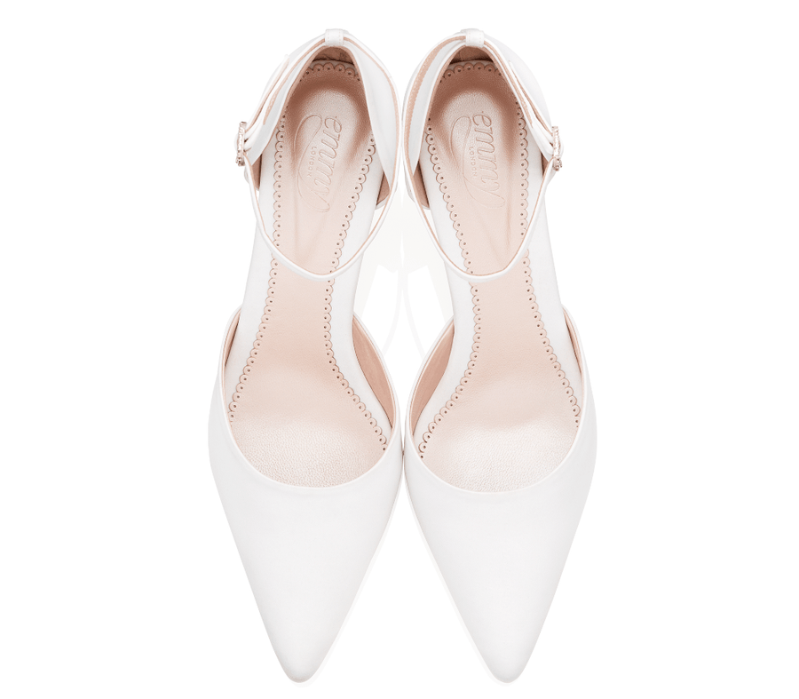 White pointed-toe heels with a sleek design, featuring a delicate ankle strap. The shoes are displayed from a top-down angle against a plain white background, highlighting their smooth finish and elegant silhouette. image