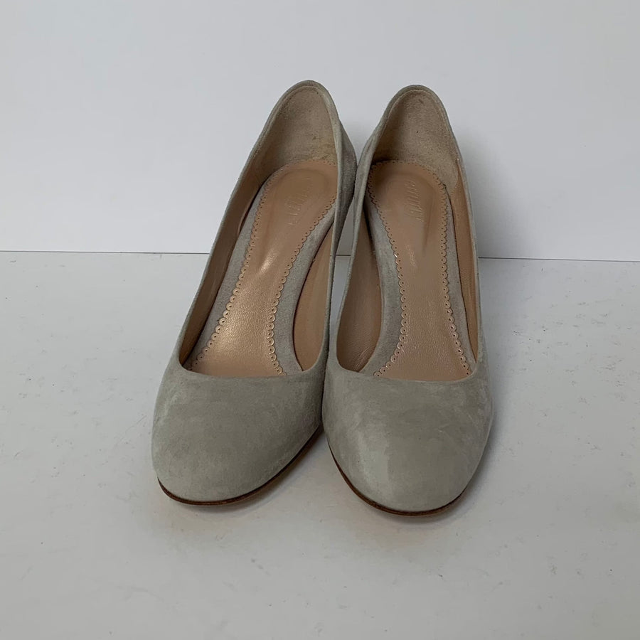 Light gray suede heels with a rounded toe and a smooth finish. The shoes are displayed on a white surface against a plain white background, showcasing their elegant design. The angle of the image highlights the shoes from the front, emphasizing the soft texture of the material. image
