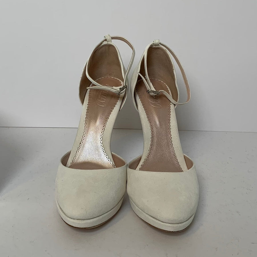 White suede heels with a rounded toe and ankle strap, set against a plain white background. The shoes are displayed from a top-down angle, showcasing their smooth texture and elegant design. image