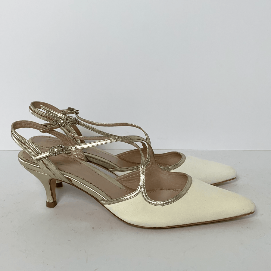 Elegant cream-colored slingback heels featuring a pointed toe and delicate gold straps. The heels are mid-height, providing a stylish yet comfortable lift. The shoes are displayed against a plain white background, allowing the design to stand out clearly. image