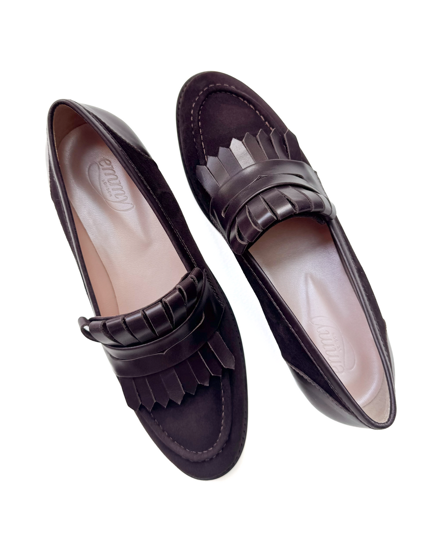 Elegant dark brown loafers featuring a decorative fringe detail across the front. The shoes have a sleek design with a rounded toe and a smooth interior. The image is taken from a top-down angle, showcasing the shoes against a clean white background. image