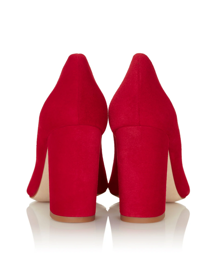Red suede heels with a chunky block heel, showcasing a sleek silhouette. The image is taken from the back, highlighting the smooth texture and vibrant color against a clean white background. image