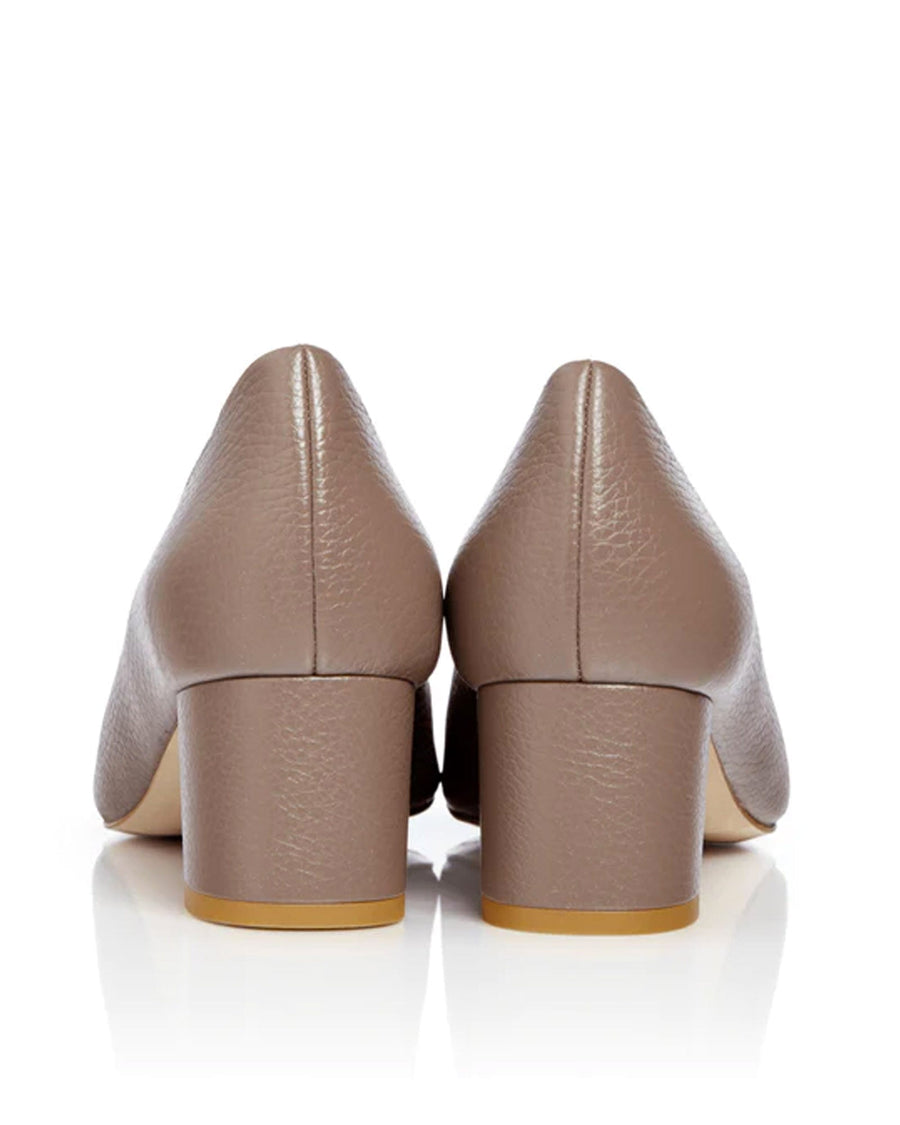 Block-heeled shoes in a soft taupe leather finish, featuring a rounded toe and a modest heel height of approximately 2.5 inches. The image is taken from the back, showcasing the smooth texture of the leather and the sturdy block heel against a clean white background. image
