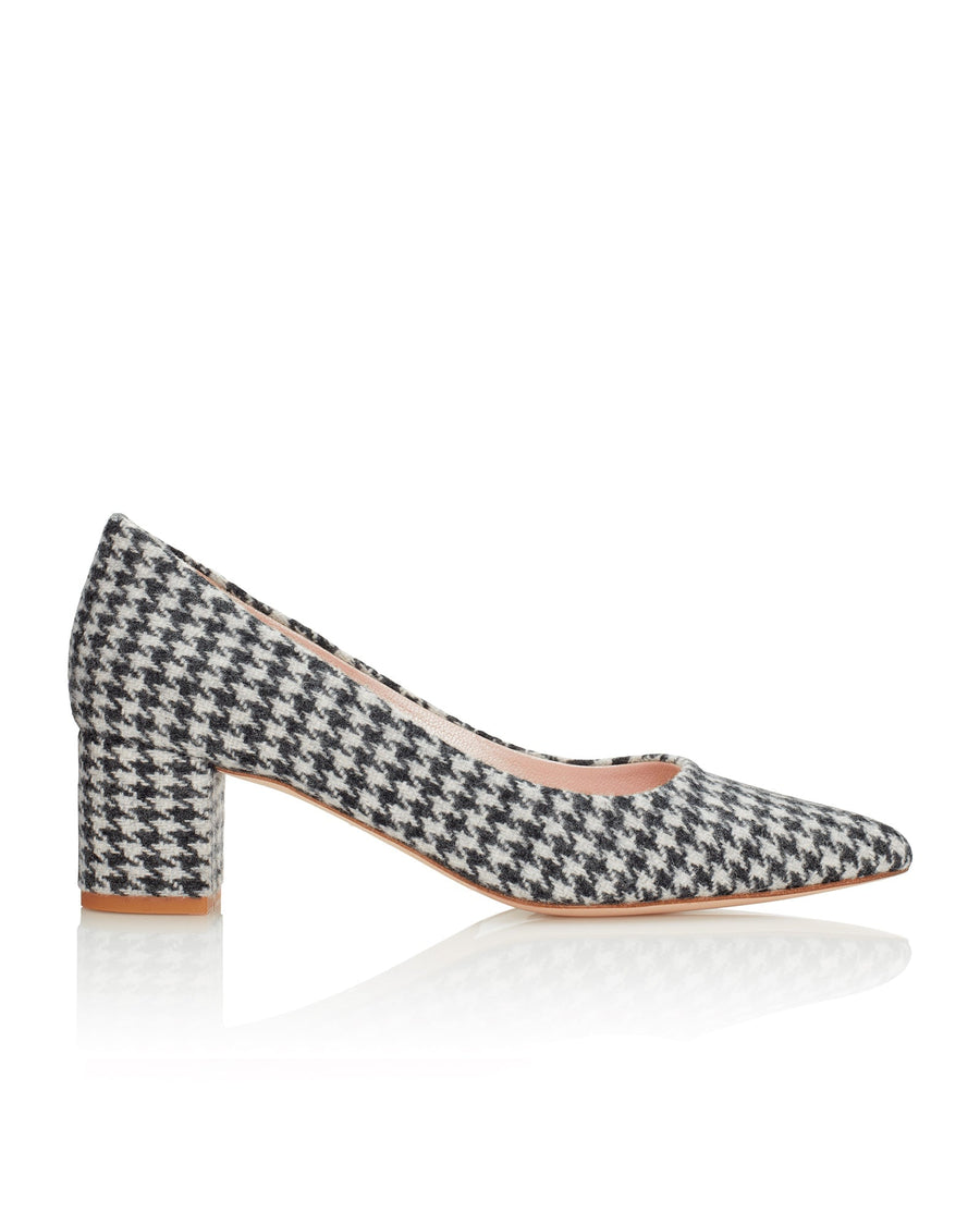 Houndstooth tweed pumps with a block heel, showcased from a side angle against a white background. The shoe features a pointed toe and a sturdy heel, providing a stylish yet comfortable fit. image