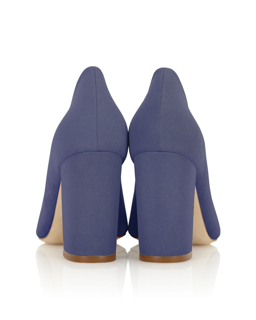 Block-heeled shoes in a rich navy suede, featuring a rounded toe and a wide heel for stability. The image shows the back view against a clean, white background, highlighting the smooth texture of the material and the elegant silhouette. image