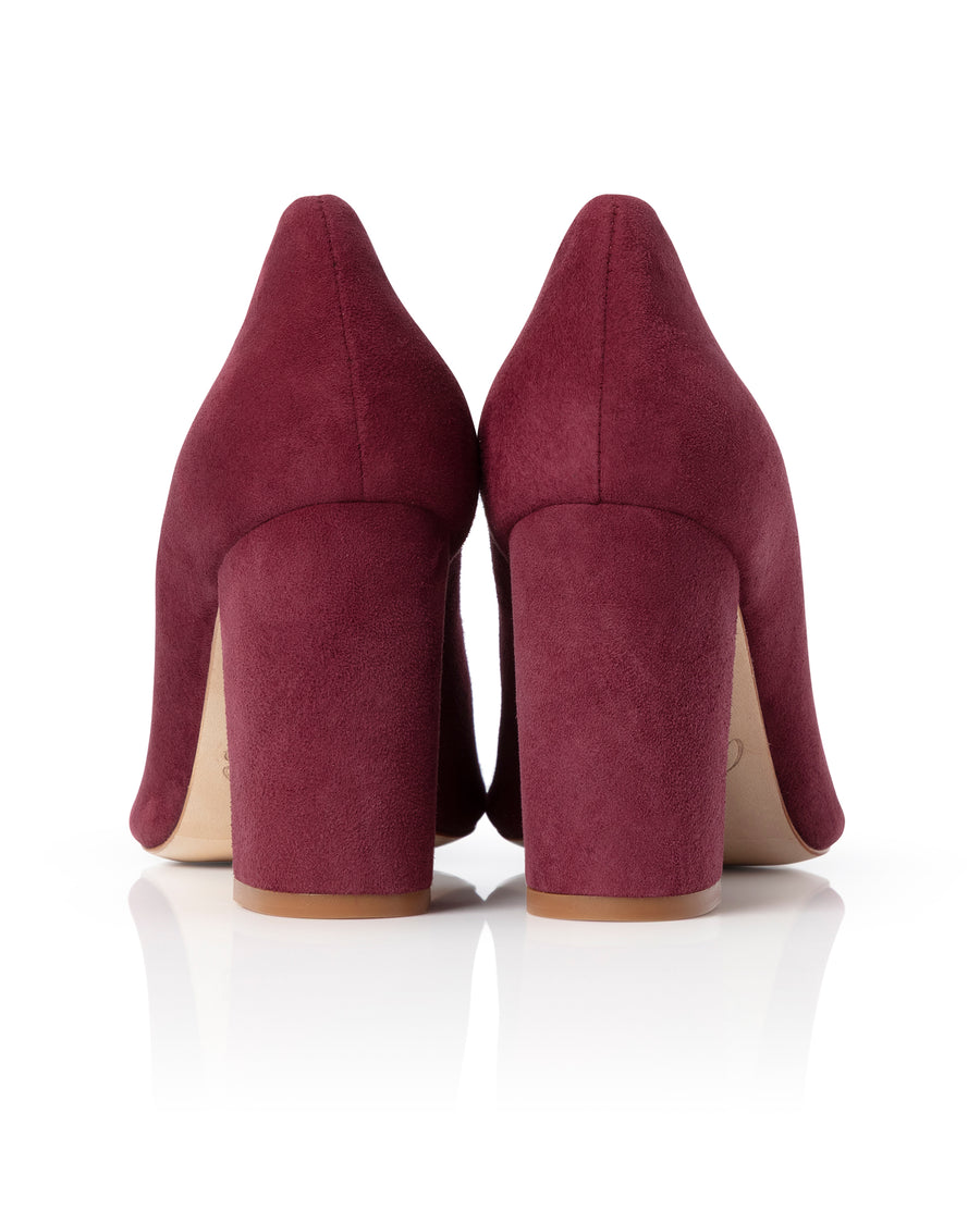 Pair of maroon high-heeled shoes on a white background image