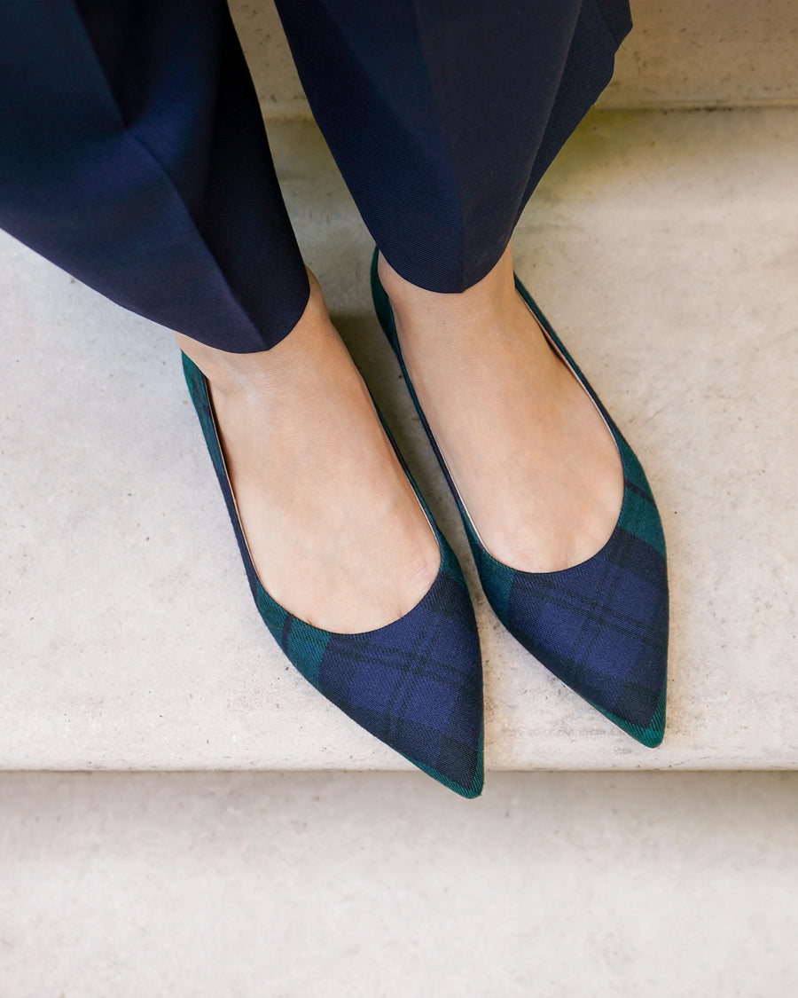 Blue and green checkered shoes worn with navy pants on a light background image