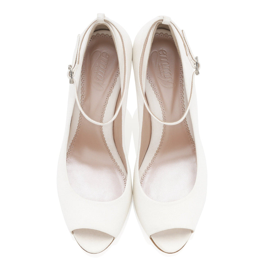 White open-toe heels with a strap across the ankle, featuring a smooth finish. The shoes are displayed from a top-down angle against a plain white background, highlighting their elegant design. image