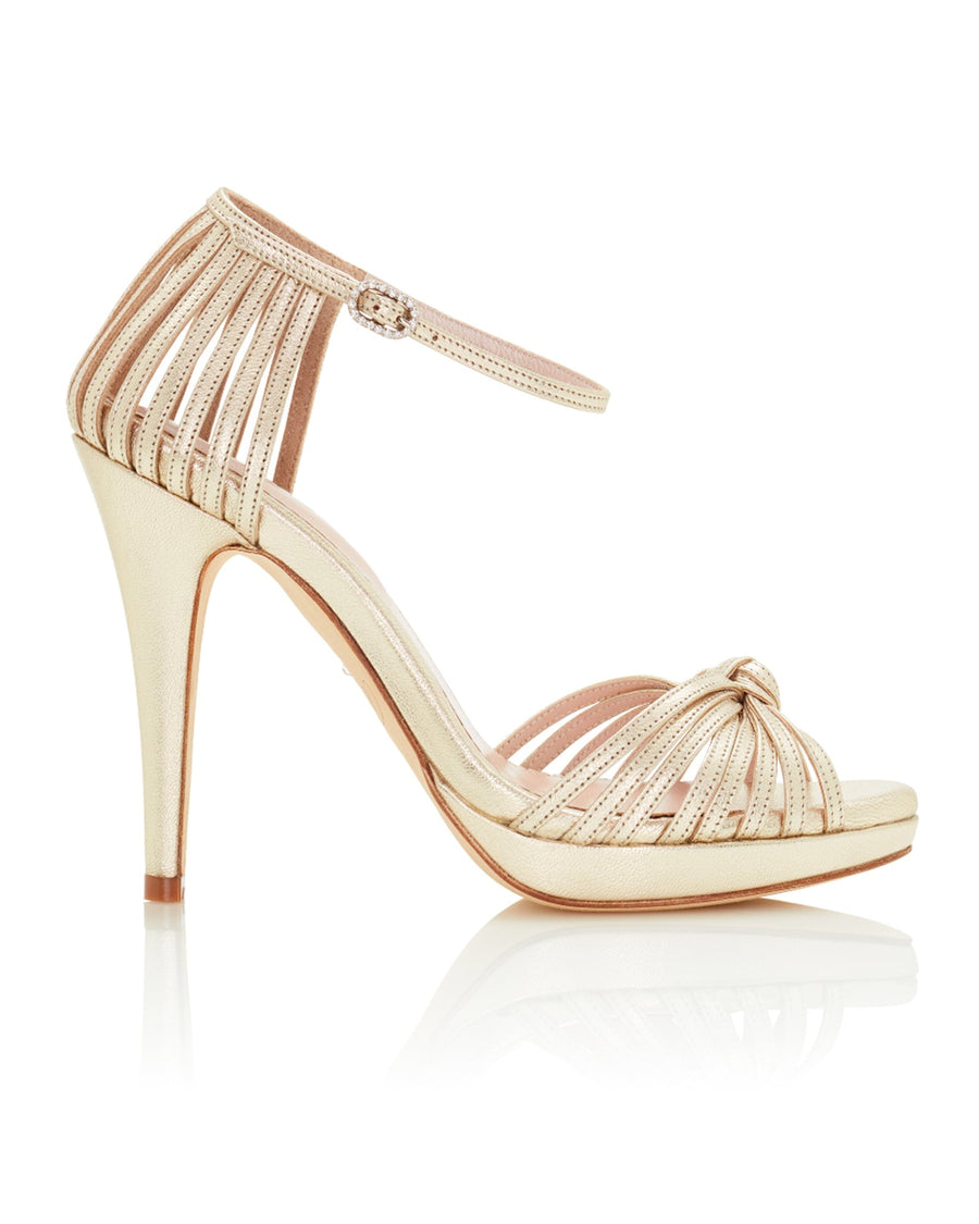 Strappy high-heeled sandals featuring a sleek design with a knotted front detail. The heels are approximately 4.5 inches tall and made of leather. The image showcases the shoes from a side angle against a clean, white background, highlighting their elegant silhouette. image