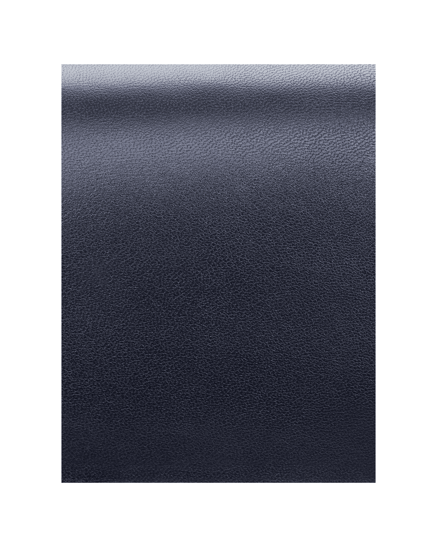 The image shows a close-up of a textured dark blue material, likely leather. There are no shoes or heels present in the image. image