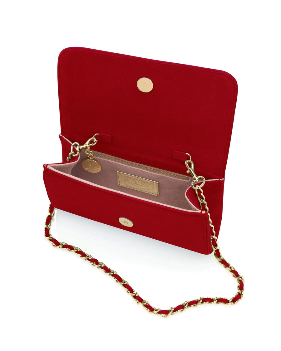 Red suede handbag with a gold chain strap, displayed open to show the interior. The background is plain white, highlighting the bag's vibrant color and elegant design. image