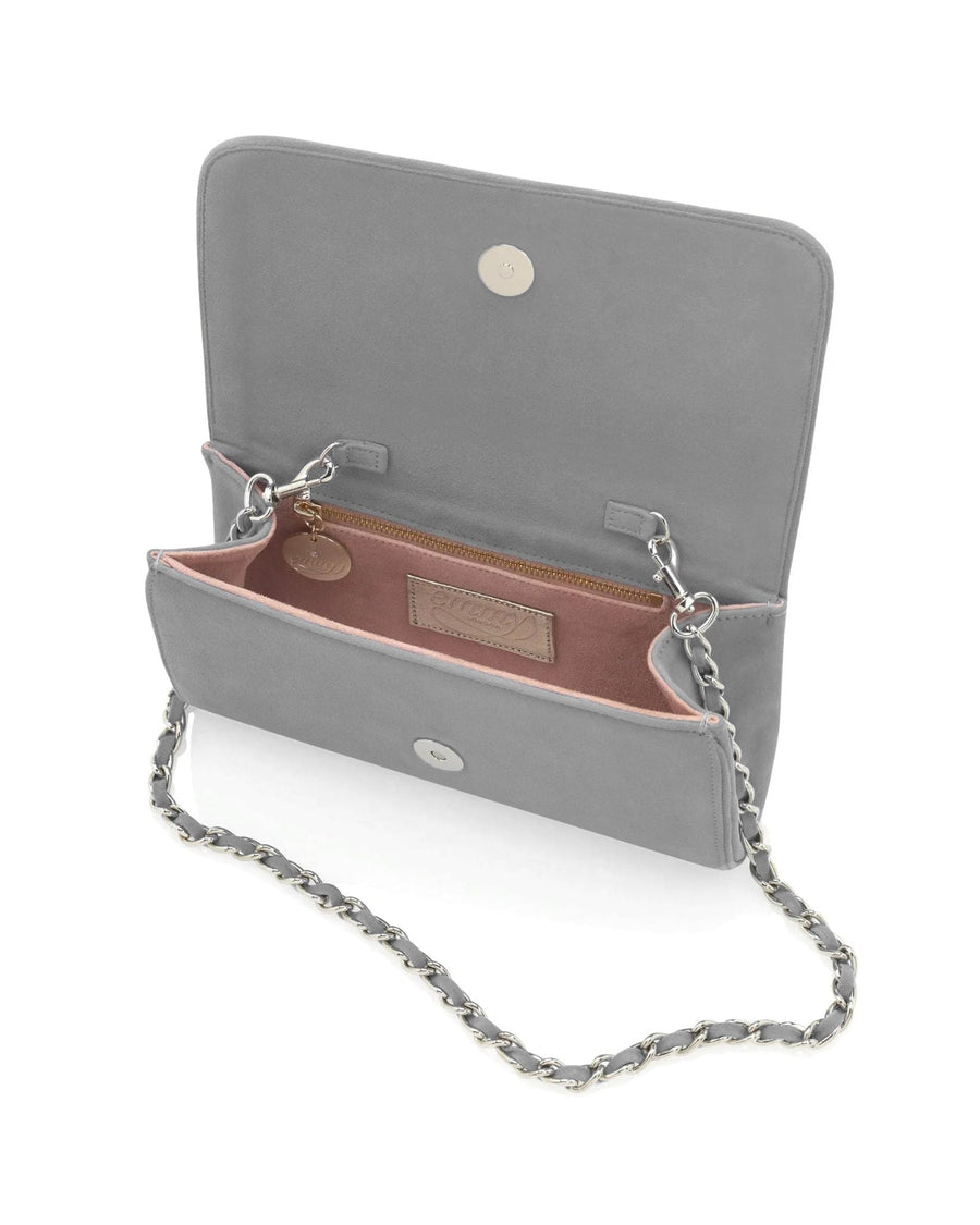 Gray suede handbag with a chain strap, featuring a spacious interior and a pink lining. The bag is open, showcasing its compartments and a small tag inside. The image is taken from a top-down angle against a neutral background. image