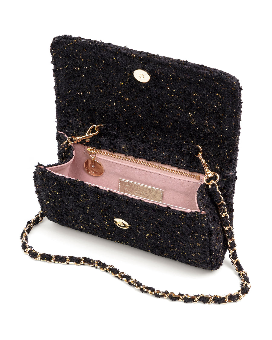 Black textured handbag with gold chain strap on a white background image