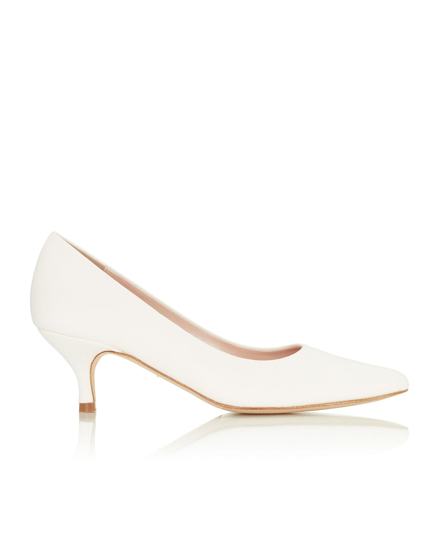 White leather heels with a pointed toe design, featuring a low kitten heel. The shoes are displayed against a clean, white background, showcasing their sleek silhouette from a side angle. image