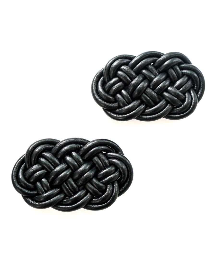 Black woven leather shoes with a flat sole, displayed against a white background. The shoes feature an intricate braided design, showcasing a stylish and modern aesthetic. image