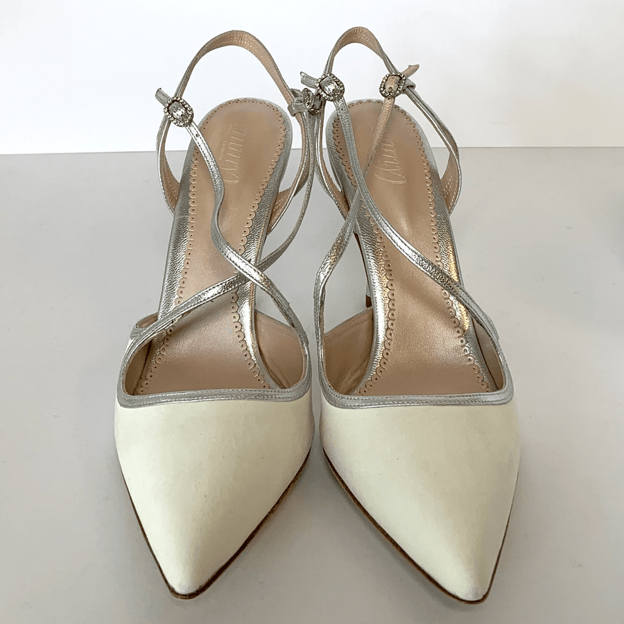 Elegant pointed-toe heels featuring a delicate crisscross strap design. The shoes are primarily white with a smooth finish, set against a clean, neutral background. The image captures the shoes from a top-down angle, showcasing their sleek silhouette and the subtle shine of the straps. image