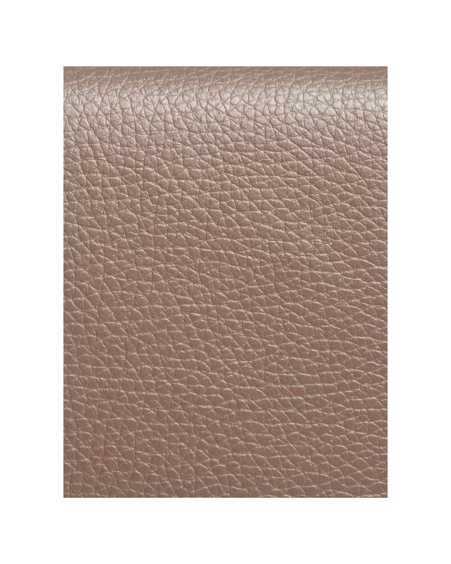 The image shows a close-up of a textured leather material in a soft taupe color. The surface has a natural grain, highlighting its quality and durability. The background is plain, allowing the focus to remain on the leather texture. image