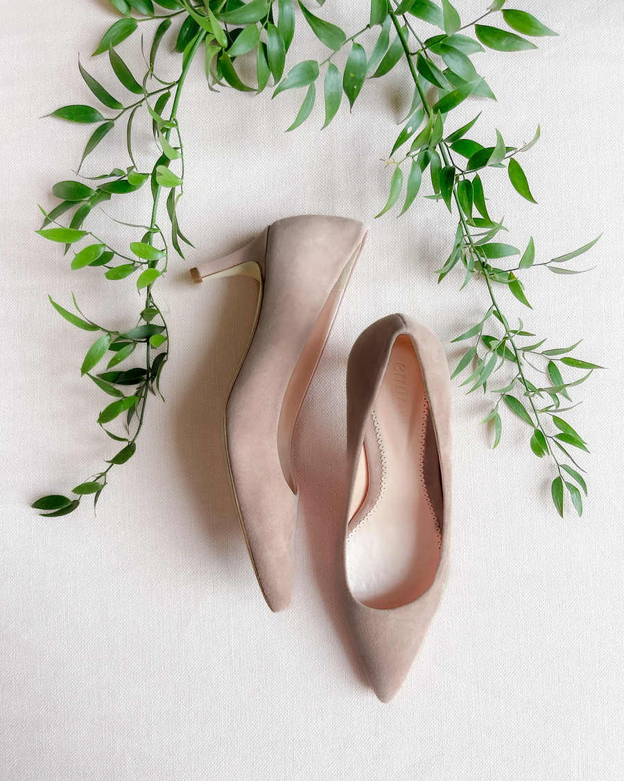 Cashmere suede pump with a pointed toe and a low-height heel. The shoe is displayed against textured background with green leaves. image