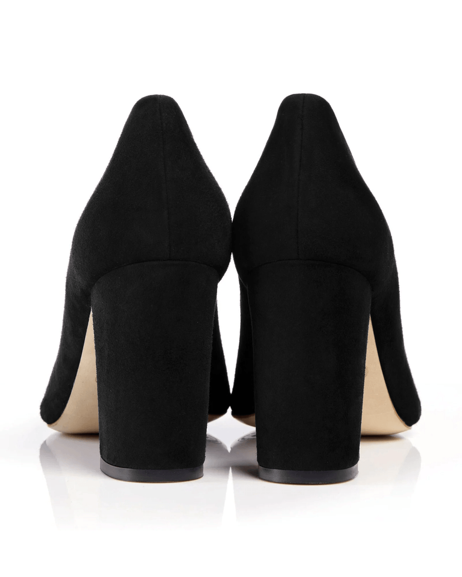 Black suede heels with a chunky heel design, viewed from the back. The background is white, highlighting the smooth texture of the suede. The heels are approximately 4 inches in height. image