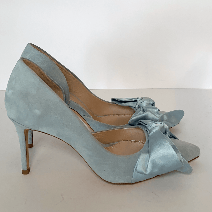 Light blue suede heels with a pointed toe and a decorative bow on the front. The shoes are displayed on a plain white background, showcasing their elegant design. The heel height is approximately 3 inches. image