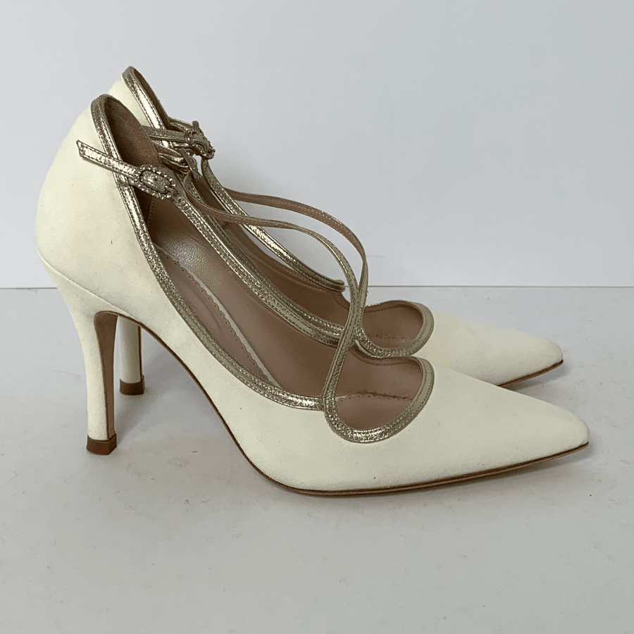 White suede heels with a pointed toe and gold straps, featuring a stiletto heel. The shoes are positioned side by side against a plain white background, showcasing their elegant design. image