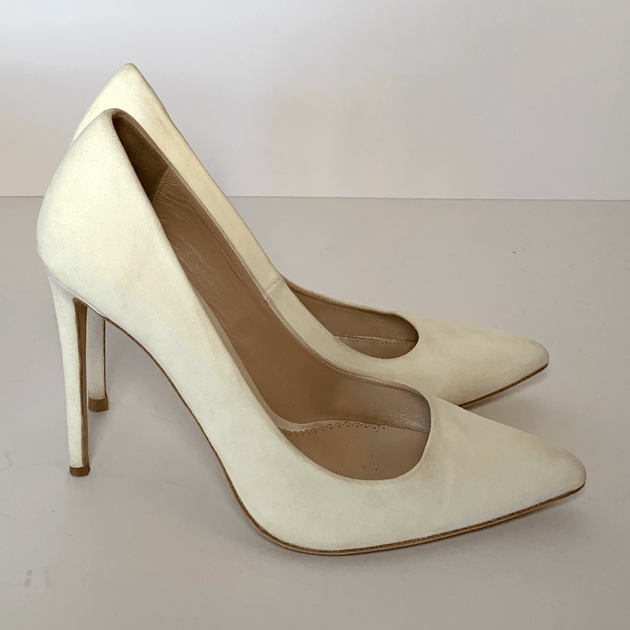 White suede high heels with a pointed toe design, displayed on a plain white background. The shoes are positioned at an angle, showcasing their sleek silhouette and elegant style. image