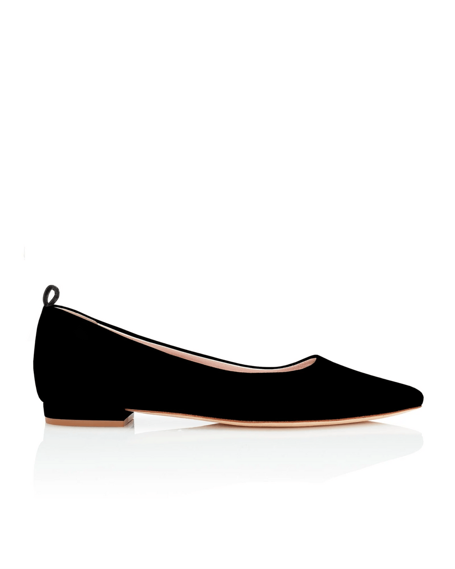 Black suede flats with a low heel, displayed against a white background. The shoe features a sleek, pointed toe and a small loop at the back. The image is taken from a side angle, showcasing the elegant silhouette of the shoe. image