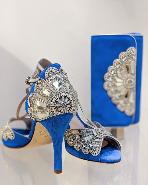 Blue suede high heels with intricate beading and embellishments, paired with a matching blue clutch. The shoes are displayed at an angle, showcasing their elegant design and detailing against a light background. image